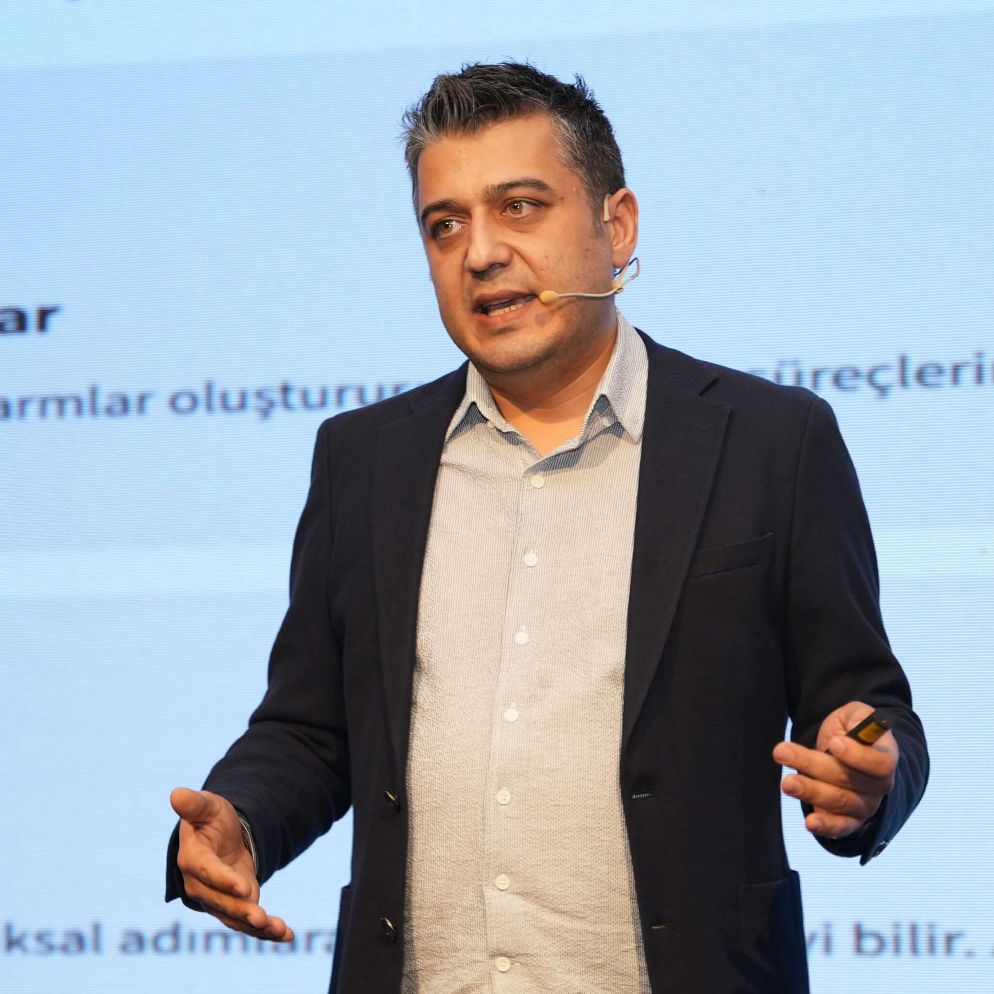 Onur Zeybek speaking and holding a presentation remote